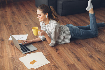 Wall Mural - Side on of female working on floor with laptop