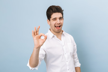 Wall Mural - Portrait of a cheerful handsome young man standing