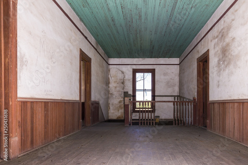 Hallway Leading To Stairwell In Old Farmhouse With Wainscoting And