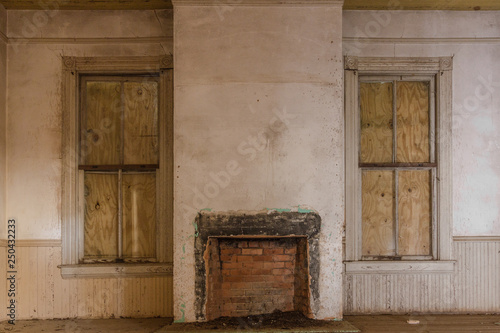 Covered Windows And Old Brick Fireplace In A Vintage Abandoned