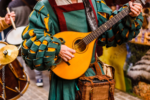 Fotografía Medieval troubadour playing an antique guitar.