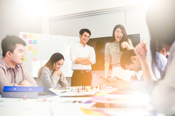 Wall Mural - Businesswoman presenting to colleagues at a meeting.Successful team leader and business owner leading informal in-house business meeting. Businessman working on laptop in foreground.