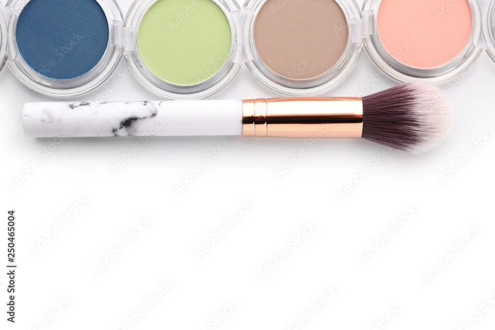 Makeup brush and eyeshadows on white background