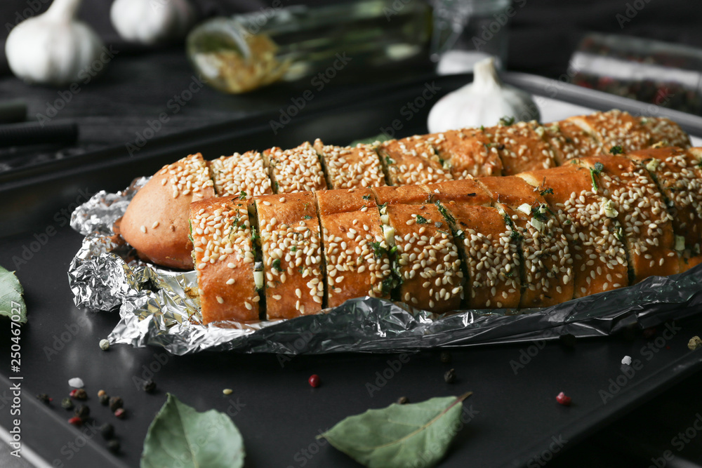 Tasty cut garlic bread on baking tray
