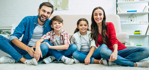 Young happy family relax together at home smiling and hugging