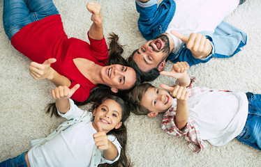 Top view photo of young happy family lying on the floor, have a fun and smiling