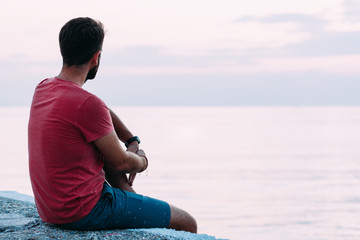 Wall Mural - Young man enjoying blue hour by the sea