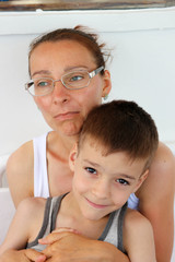 mother and son having fun make faces in warm sunny day closeup