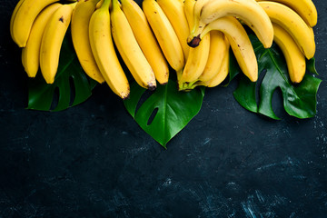 Fresh yellow bananas on a black stone table. Top view. Free copy space.