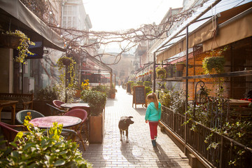 Little girl with dog on Old Tbilisi street in January, Georgia