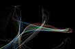 Multicolored curled line - ribbon painted by light on the black background. Improvisational painting by light.