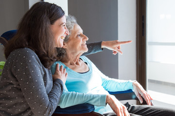 Joyful woman taking care of elderly mother