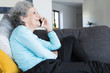 © Mangostar - Portrait of grandma lying on couch and talking on cellphone