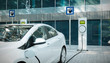 canvas print picture - electric car charging at public charger in city 3d illustration