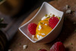 Cream fruit dessert with mango passion fruit sauce and raspberries and meringue 