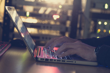 IT specialist works in a server room on a computer