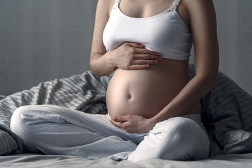 Wall Mural - unrecognizable pregnant woman practiced in meditation in the pose of a hero. Motherhood, pregnancy, the concept of prenatal yoga