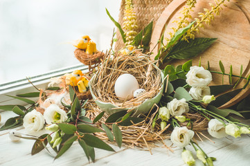 Happy Easter background. Easter egg in a nest with floral decoration near the window. Quail eggs. Happy Easter concept