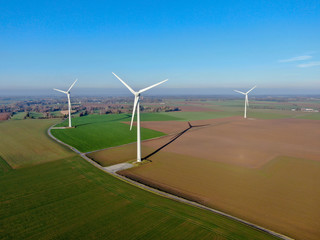 aerial view of wind turbines and agricultural fields on a beautiful blue winter day - energy product