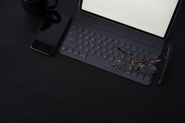 Business Items tablet, pen, mobile phone  on dark wood workspace table and copy space