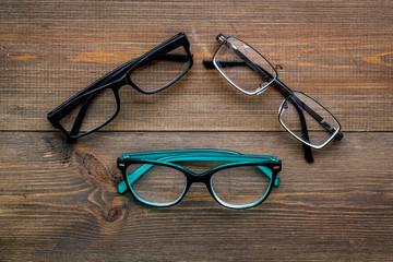 Poster - Set of glasses with transparent lenses on dark wooden background top view