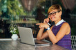 © yurakrasil - Woman freelance freelancer with laptop on the beach sitting in summer cafe .business lady remote work surfer surfing online browser