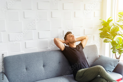 Fotografía Businessman in casual relaxing on sofa with soft sunlight