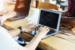 © tawanlubfah - Closeup of hands using laptop and internet on table. Wireless network connection.