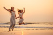 © yurakrasil - Happy mother and young daughter on the beach at sunset having fun at the seaside. playing jumping and rejoicing woman and her child copy space copyspace