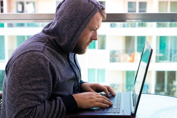 cybercrime, hacking and technology concept - male hacker writing code or using computer virus progra