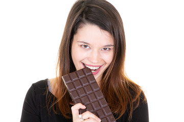 Portrait of a satisfied pretty girl biting chocolate bar smiling on white background