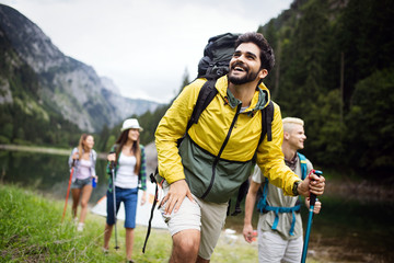 group of young friends hiking in countryside. multiracial happy people travelling in nature