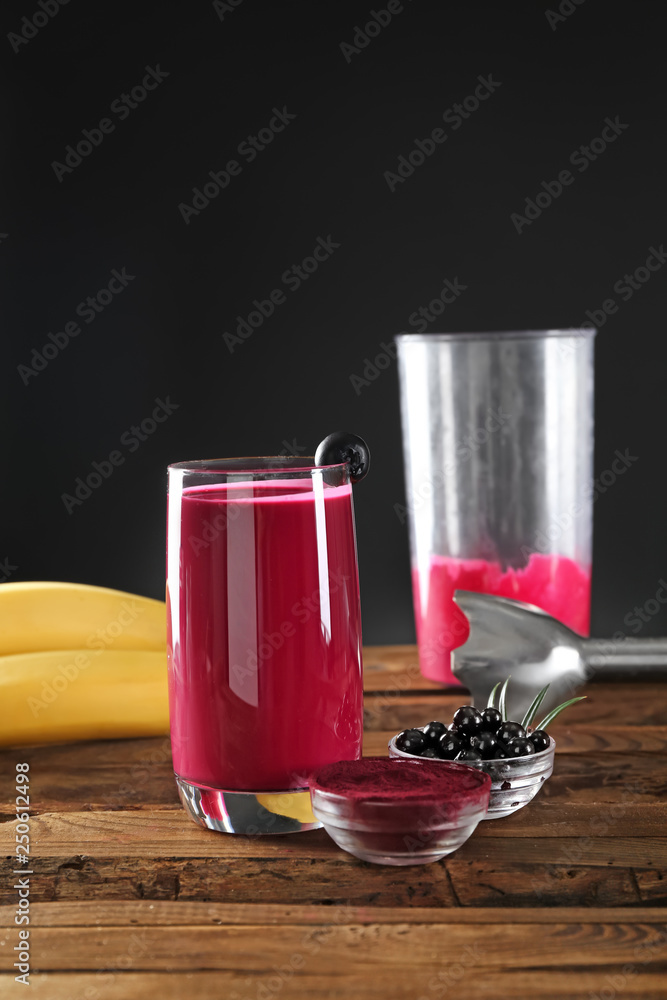 Glass of acai smoothie on wooden table