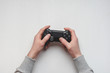 © solidmaks - Hand hold new joystick isolated. Gamer play game with gamepad controller. Gaming man holding simulator joypad. Person with keypad joystic in arms. Sleeve hands hold toy equipment. Modern manipulator.