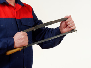 Wall Mural - man in overalls holds a hacksaw tool on a white background.