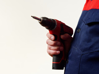 Wall Mural - man in workwear holds a drill tool on white background.