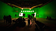 © belolipetskiyra - Behind the scenes or the making of film video production and movie crew team working in silhouette of camera and equipment set in studio