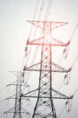 High voltage pole, High voltage electric transmission pylon silhouetted tower.