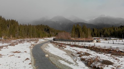 Wall Mural - Aerial panoramic view of mountain valley in winter with snow, forest and river