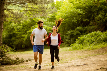 Healthy fit and sportive couple running in nature