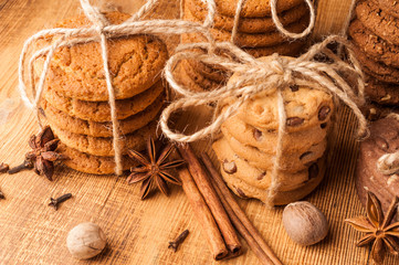 Various shortbread, oat cookies, chocolate chip biscuit and spice on dark rustic wooden table.