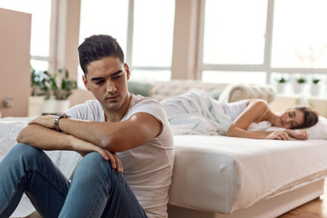 Young sad man thinking about relationship problems he has with his girlfriend.