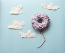 Concept Purple Donuts On A Blue Background With Clouds Minimalism