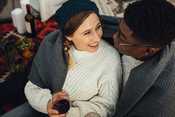 Wall Mural - happy interracial couple enjoying picnic