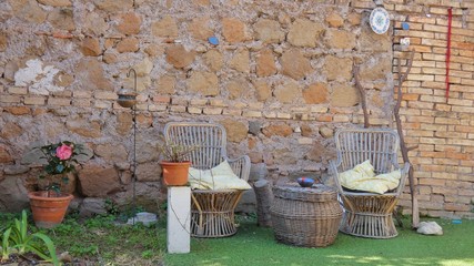 two armchairs and a wicker table on the street