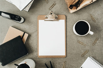 Wall Mural - Flat lay of clipboard with copy space blank mock up. Top view home office desk workspace decorated with wooden board, coffee, notebook and stationery. Social media / blog / website mockup concept.