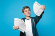 © ViDi Studio - Smiling pretty young man in casual clothes holding fan of money in dollar banknotes, cash money isolated on blue background in studio. People sincere emotions, lifestyle concept. Mock up copy space.