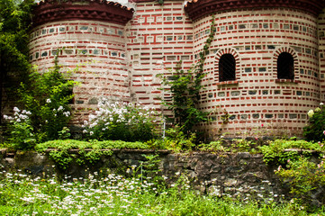 Wall Mural - Orthodox medieval byzantine style church facade and green monastery garden