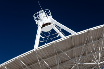 Wall Mural - very large array close view of underside of a radio antenna dish vla against a deep blue sky, space 