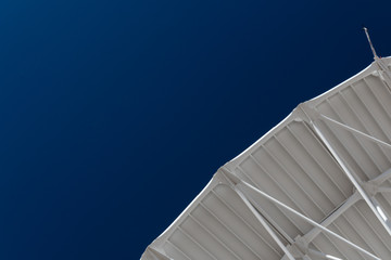 Wall Mural - very large array curved edge of a radio telescope dish against a flawless blue sky, copy space, hori